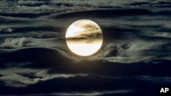 FILE - The full moon shines surrounded by clouds in the outskirts of Frankfurt, Germany, Sept. 2, 2020.