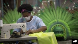 Carmen, a worker from the Vila Isabel samba school makes a medical scrub, during the new coronavirus pandemic in Rio de Janeiro, Brazil, Tuesday, April 7, 2020. (AP Photo/Silvia Izquierdo)