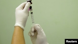 FILE - A health agent prepares a vaccine in Rio de Janeiro. Researchers in Brazil developed a vaccine to fight addiction to cocaine. 