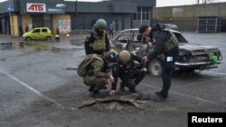 جای گلوله روی آسفالت پارکینگ جلوی یک سوپر مارکت پس از حمله روسیه به خرسون. ۲۰ اسفند ۱۴۰۱