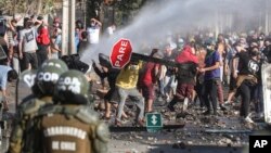 Manifestants réclamant une aide alimentaire de l'Etat dans un quartier pauvre de Santiago, Chili, 18 mai 2020. (AP Photo/Esteban Felix)