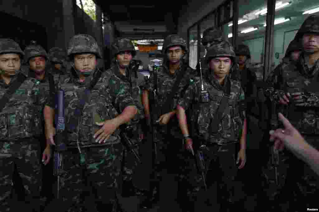 A man gestures towards soldiers arriving to control a protest against military rule in central Bangkok, May 23, 2014.