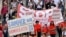 FILE - People hold placards and banners during a demonstration called by far-right and COVID-19 deniers to protest restrictions related to the coronavirus pandemic, in Berlin, Aug. 29, 2020.