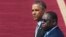 U.S. President Barack Obama and Senegalese President Macky Sall (R) watch a military band play at the airport in Dakar, Senegal, June 28, 2013.