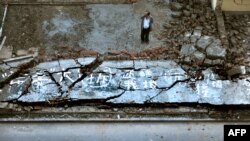 FILE - A man looks at a demolished wall in Beijing, May 31, 2010. The Chinese government is cracking down on properties it says were illegally built. In early December 2020, residents in in Xiangtang Village were told their homes would be demolished. 