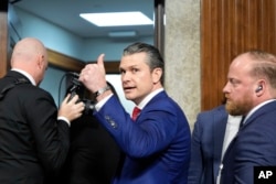 Pete Hegseth, calon Menteri Pertahanan pilihan Presiden terpilih Donald Trump, mengacungkan jempol saat meninggalkan gedung DPR di Washington, setelah sidang konfirmasi Komite Angkatan Bersenjata Senat, pada 14 Januari 2025. (Foto: AP)