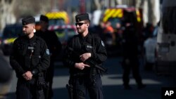 Petugas Kepolisian Perancis memasang garis polisi di sekitar lokasi serangan teror di Trebes, selatan Perancis, 23 Maret 2018.