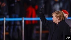 German Chancellor Angela Merkel waves goodbye at the Defense Ministry during the Grand Tattoo (Grosser Zapfenstreich), a ceremonial send-off for her in Berlin on Dec. 2, 2021.