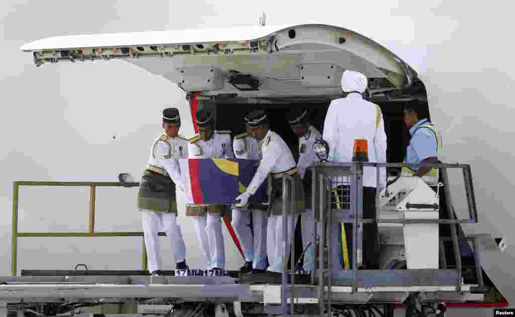 The remains of a passenger of the downed Malaysia Airlines MH17 is removed from a transport plane at KLIA airport in Sepang, Aug. 22, 2014.