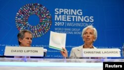 La directrice du FMI Christine Lagarde (à droite) tient un rapport du FMI et de la Banque mondiale, avec le premier député David Lipton, à Washington, le 20 avril 2017. 