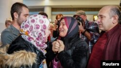 Reaksi pengungsi Suriah, Baraa Haj Khalaf (kiri), saat bertemu ibunya, Fattoum (tengah), dan ayahnya Khaled, setelah tiba di Bandara Internasional O'Hare di Chicago, 7 Februari 2017.