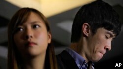 Newly elected Hong Kong lawmakers Yau Wai-ching (left) and Sixtus Leung react during a press conference outside the high court in Hong Kong, Nov. 15, 2016. Two newly elected Hong Kong separatist lawmakers who used anti-China insults when being sworn in were disqualified from taking office in a court decision.