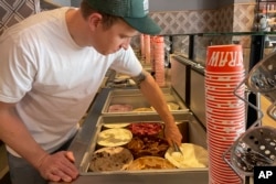 Salt & Straw Ice Cream Co-Founder Tyler Malek scoops "Day-Old Bread Pudding" upcycled ice cream at the franchise's newest location in Los Gatos, Calif., Friday, June 2, 2023. World Upcycling Day is June 24, celebrating the repurposing of old products into something new. This year, the movement is focusing on upcycling food, like misshapen produce or offcuts of meat, as a way to prevent food waste.