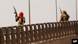 23일 부르키나파소 수도 와가두구 시내 교차로에 선 군인이 공중으로 발포하고 있다. 