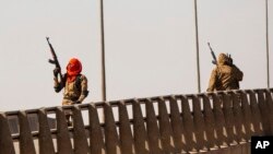 Tentara pemberontak menembakkan senjata mereka ke udara di persimpangan Bobo, dekat kamp Lamizana di ibu kota Burkina Faso, Ouagadougou, pada 23 Januari 2022. Saksi menyebutkan telah mendengar suara tembakan yang berasal dari pangkalan militer. (Foto: AP/Sophie Garcia)