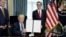 U.S. President Donald Trump displays a financial services executive order as Treasury Secretary Steven Mnuchin looks on during a signing ceremony at the Treasury Department in Washington, April 21, 2017.