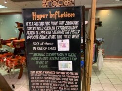 A trader displays former currencies that Zimbabwe had during a hyperinflationary era about 10 years ago, in Victoria Falls, Zimbabwe, June 25, 2019. (Columbus Mavhunga/VOA)