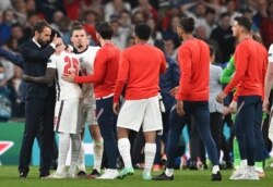 England's manager Gareth Southgate, left, embraces Bukayo Saka after he failed to score a penalty during a penalty shootout during of the Euro 2020 soccer championship final match between England and Italy at Wembley stadium in London, July 11, 2021.