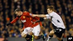 Pemain Fulham John Arne Riise (kanan) berebut bola dengan pemain Manchester United Wayne Rooney (foto: dok). 