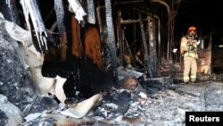 A firefighter stands on debris at a burnt hospital in Miryang, South Korea, Jan. 26, 2018. 