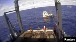 An unmanned capsule of the SpaceX Crew Dragon spacecraft is seen shortly after splashing down into the Atlantic Ocean as SpaceX recovery teams works on it, in this still image from video from NASA Commercial Crew, in the Atlantic, off the Florida coast, U.S., March 9, 2019.