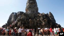 In this Sunday, Dec. 31, 2017, photo, tourists line up for stepping up Angkor Wat temple outside Siem Reap, Cambodia. Tourists celebrated New Year at Angkor Wat temple where is Cambodia's main tourist destination. The temples, built between the 9th and 15th centuries. (AP Photo/Heng Sinith)