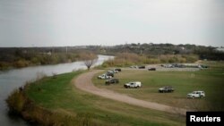 FILE - U.S. border patrol cars are seen through the fence of the bridge connecting Eagle Pass, Texas, with Piedras Negras, Mexico, near the banks of Rio Bravo, from Piedras Negras, Mexico, Feb. 7, 2019. 