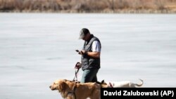 ແຟ້ມພາບ - ຊາຍຄົນນຶ່ງກຳລັງຈູງໝາຍ່າງຫຼິ້ນ ຂະນະທີ່ເບິ່ງໂທລະສັບມືຖືໄປພ້ອມ ທີ່ສວນວໍຊິງຕັນ ພາກຣ໌ ນະຄອນເດັນເວີ ລັດໂຄໂຣລາໂດ ເມື່ອວັນທີ 21 ກຸມພາ 2023. (AP Photo/David Zalubowski, File)