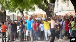 FILE - In this photo taken Oct. 26, 2015, youths supporting the opposition party dance and chant, predicting a win for their candidate, outside the Electoral Commission office in Stone Town, Zanzibar, a semi-autonomous island archipelago of Tanzania. Zanzibar is preparing for an election rerun Sunday, after polls were nullified in the region last year. 