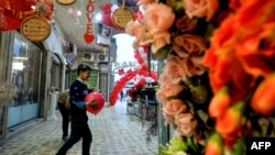 Children play with red balloons that are part of Valentine's day decorations at a shopping mall in Iraq's northern city of Mosul on February 13, 2020. (Photo by Zaid AL-OBEIDI / AFP) 