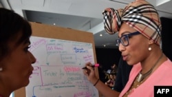 Anne Aly (L), the first Muslim woman elected to Australia's federal parliament, has spoken of how racism and domestic violence has shaped her career. 