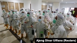 រូបឯកសារ៖ បុគ្គលិក​សុខាភិបាល​ក្នុង​ឯកសណ្ឋាន​ការពារ​ពី​ជំងឺ​កូវីដ១៩ ត្រៀម​ព្យាបាល​អ្នក​ជំងឺ​កូវីដ១៩ នៅ​មន្ទីរពេទ្យ​មួយ​ក្នុង​ទីក្រុង​ហ្សាការតា ប្រទេស​ឥណ្ឌូណេស៊ី ថ្ងៃទី២៦ ខែមករា ឆ្នាំ២០២១។ 