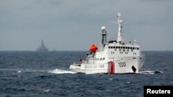 FILE - A Chinese Coast Guard vessel, with the disputed oil rig in the background, is seen in the South China Sea, June 2014.