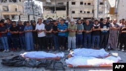 Palestinians pray by the bodies of relatives killed during an Israeli strike which hit a makeshift prayer hall at al-Shati refugee camp west of Gaza City on July 13, 2024 amid the ongoing conflict between Israel and the militant Hamas group in Gaza. (Phot