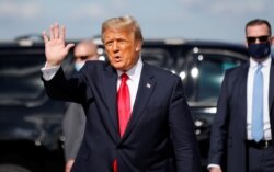 FILE - U.S. President Donald Trump waves as he arrives at Palm Beach International Airport in West Palm Beach, Fla., Jan. 20, 2021.