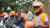 FILE - Motorcycle taxi drivers known as boda bodas, wear SafeBoda safety gear as they wait for customers along a street in Kampala, Uganda, Oct. 5, 2018.