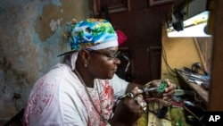 Teknisi perhiasan dan elektronik Gabriel La O memperbaiki sebuah ponsel di dalam toko pemerintah yang ia sewa di Havana, Kuba (24/5). (AP/Desmond Boylan)