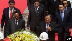 Laos President Bounnhang Vorachith, foreground right, walks together with Cambodian Defense Minister Tea Banh, foreground left, during a ceremony to pay respects at the Monument Independence in Phnom Penh, Cambodia, Wednesday, Feb. 22, 2017. (AP Photo/Heng Sinith)