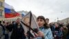 FILE - Opposition activists participate in a rally against Russian President Vladimir Putin, in Saint Petersburg, Russia, May 5, 2018.