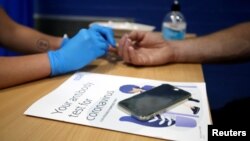 A man has his finger pricked during a clinical trial of tests for the coronavirus disease (COVID-19) antibodies, at Keele University, in Keele, Britain June 30, 2020. (REUTERS/Carl Recine)
