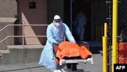 A medical staffer moves the body of a coronavirus victim from the Wyckoff Heights Medical Center to a refrigerated truck, in Brooklyn, New York, April 2, 2020.