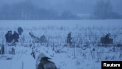 Emergency services work at the scene where a short-haul regional Antonov AN-148 plane crashed after taking off from Moscow's Domodedovo airport, outside Moscow, Feb. 11, 2018.