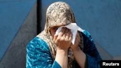 A Palestinian woman who fled the violence in Syria reacts during a sit-in in front of the United Nations Relief and Works Agency (UNRWA) in Beirut, Lwbanon, March 21, 2013. 