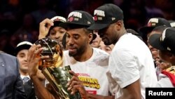 Kawhi Leonard, à gauche, tient le trophée de champion NBA, USA, le 13 juin 2019.