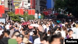 Chinese national flags are seen as tourists throng the Nanjing pedestrian road, a main shopping area, on China's 69th National Day in Shanghai, China, Oct. 1, 2018.
