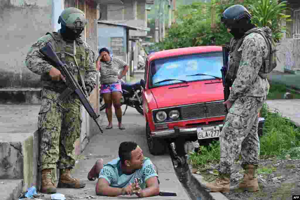Soldiers detain a man in the neighborhood where at least 22 people were killed the night before during clashes between rival drug factions in Guayaquil, Ecuador.