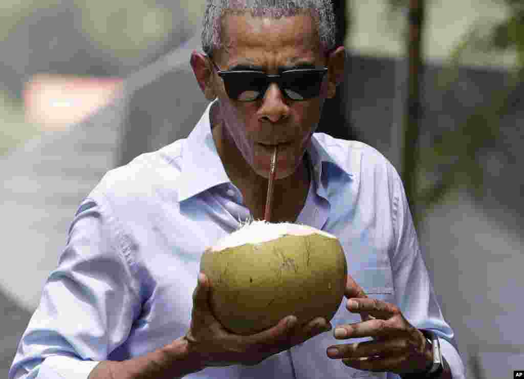 U.S. President Barack Obama drinks from a fresh coconut along the banks of the Mekong River in the Luang Prabang, Laos, Wednesday, Sept. 7, 2016.