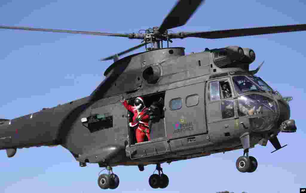 A British airman dressed as Santa Claus waves from a helicopter to a soccer match between British and German soldiers on Christmas day at Operation Resolute Support headquarters, in Kabul, Afghanistan, Dec. 25, 2016.
