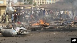 FILE - People gather at the site of a bomb explosion at a road in Kaduna, Nigeria, April 8, 2012.
