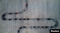 An aerial view shows vehicles waiting at a drive-thru COVID-19 testing site in a parking lot in Milwaukee, Wisconsin, Nov. 5, 2020.